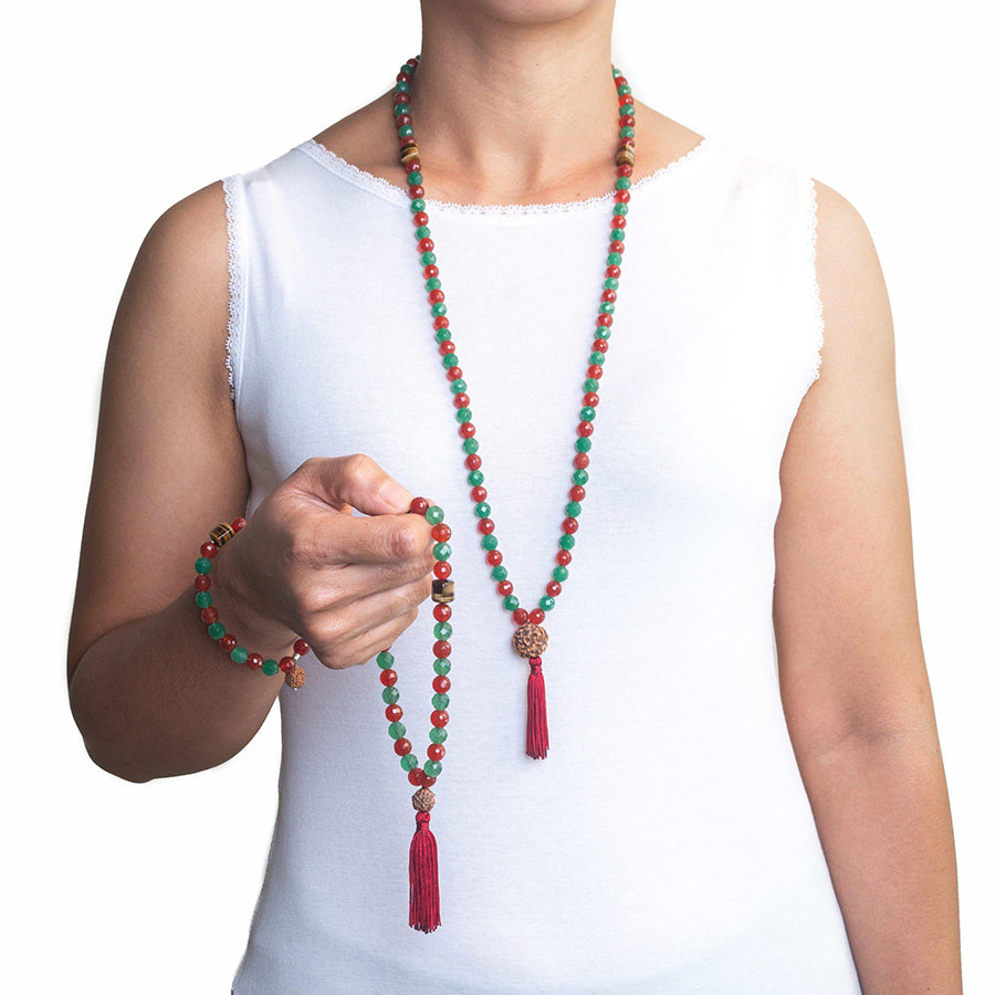prayer beads tasbih with 33 beads of mixed Carnelian 8 mm and Aventurine 8 mm and Tiger’s Eye finished with Rudraksha seed and a dark red tassel on hand of a model in white top with matching tasbih mala necklace