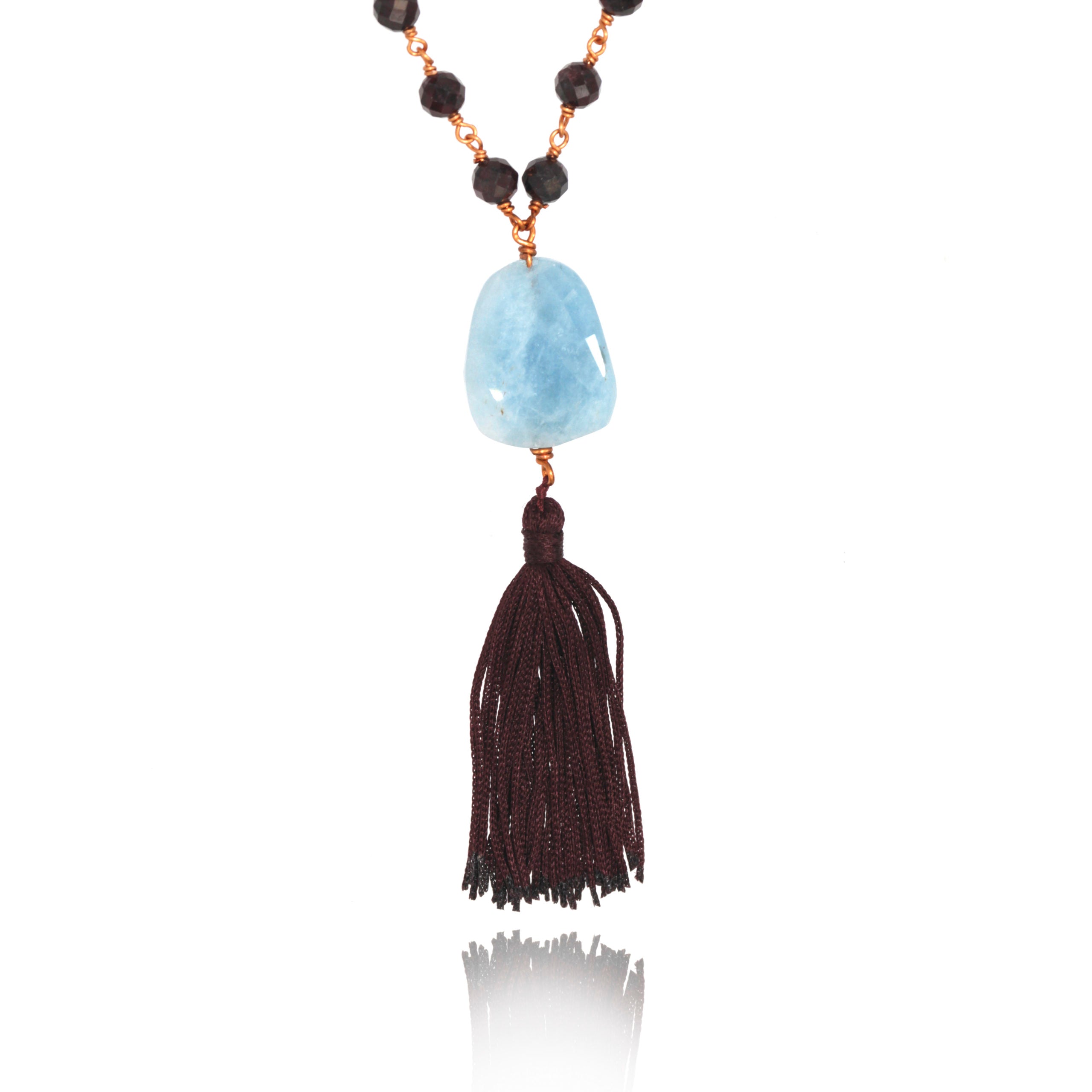 aquamarine pendant with dark red tassel in white background