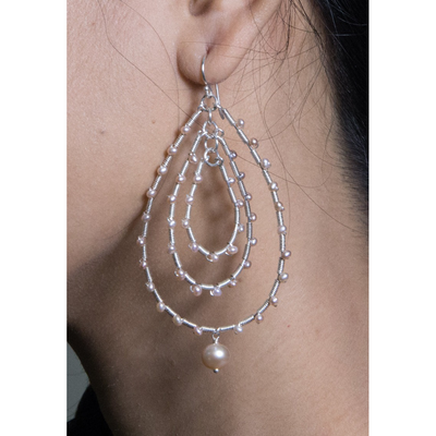 a chandelier silver earrings with baby pink pearls on model