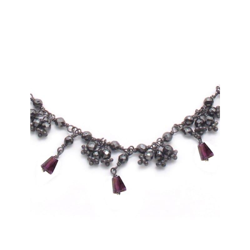 the details of garnet and hematite stones of a short silver necklace with silver 925 chain extender on white background