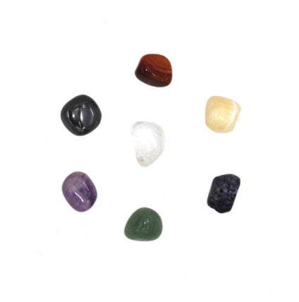 Tumble stones in hematite and carnelian and yellow Calcite and green Aventurine and Sodalite and Crystal Quartz and Amethyst Seven Chakra Stones set on white background 