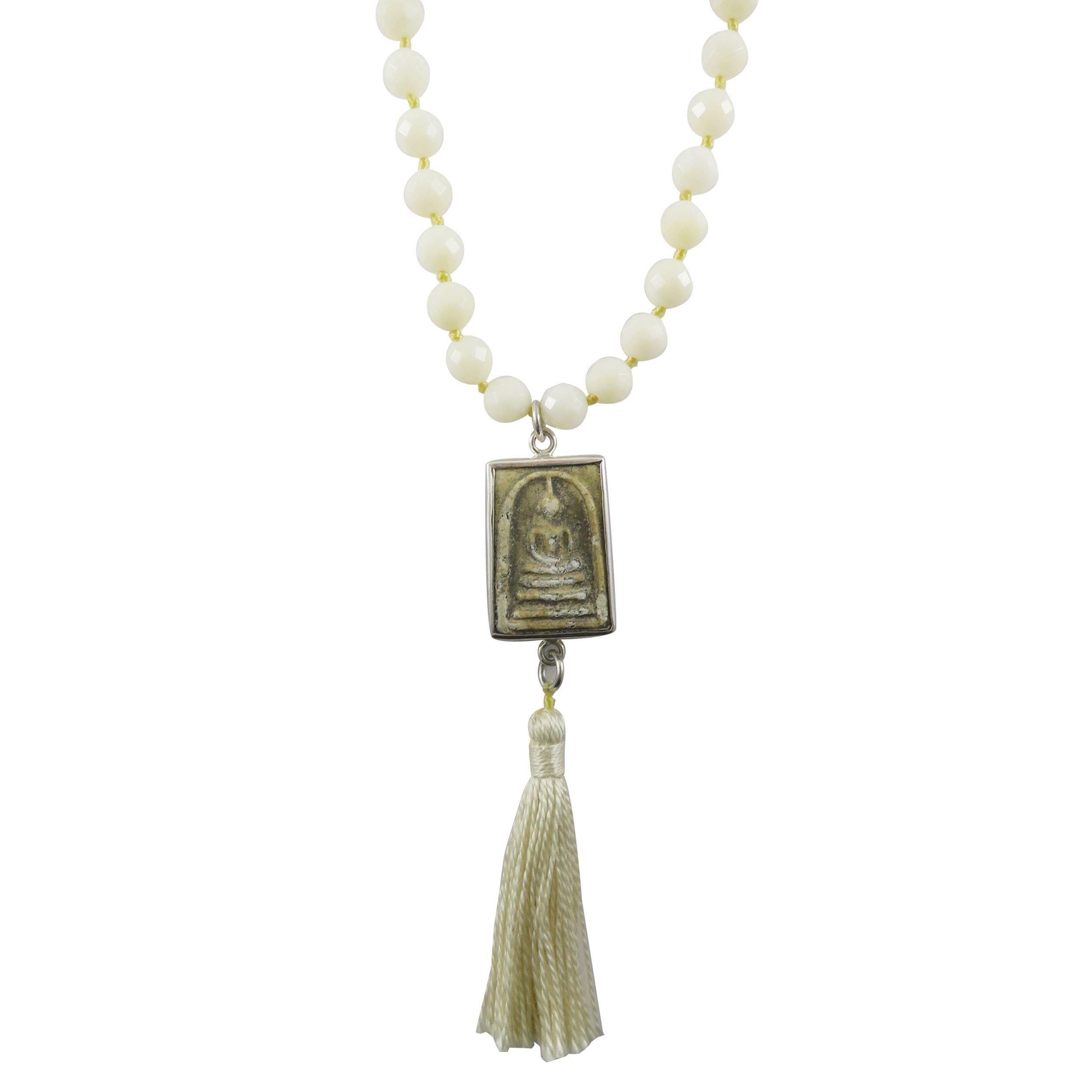 buddha craved terracotta pendant with tassel on white background