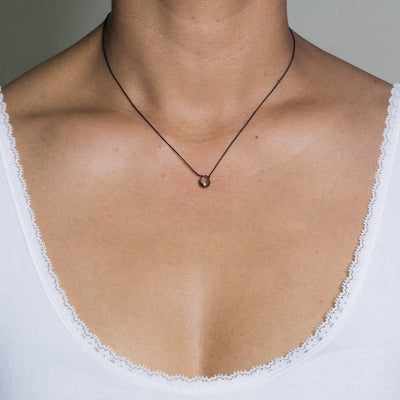 short string pendant necklace with smokey quartz drops on model in white tshirt