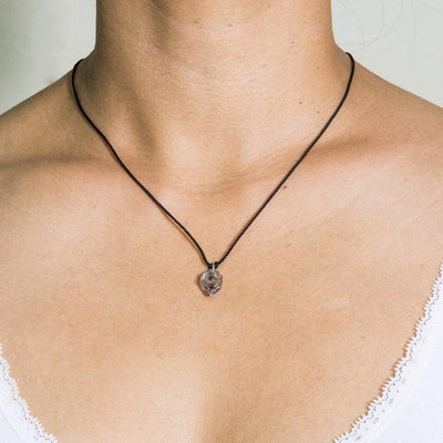 short necklace with black artificial string with herkimer diamond pendant and silver 925 clasp on model in white top