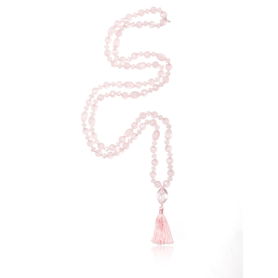 mala necklace with 126 beads of mixed shapes and sizes of rose quartz crystal with rose quartz pendant and pink tassel on white background