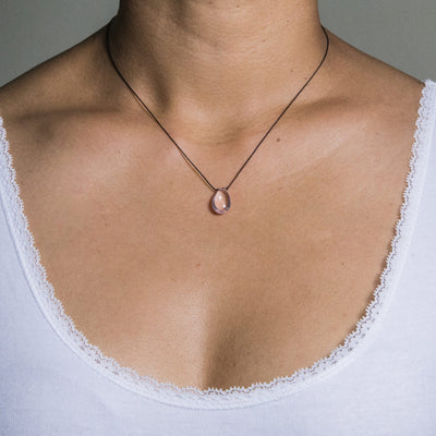 short necklace with rose quartz drop on black artificial string with silver 925 clasp short necklace on model in white top