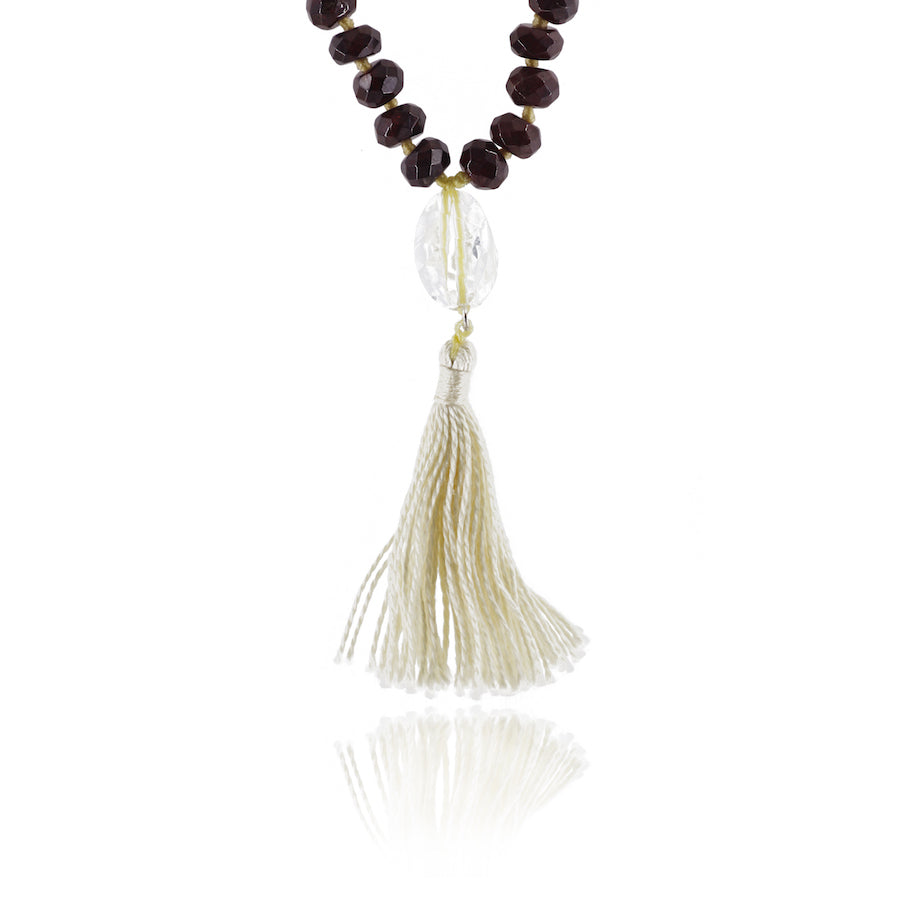 crystal clear quartz pendant and white tassle on white background