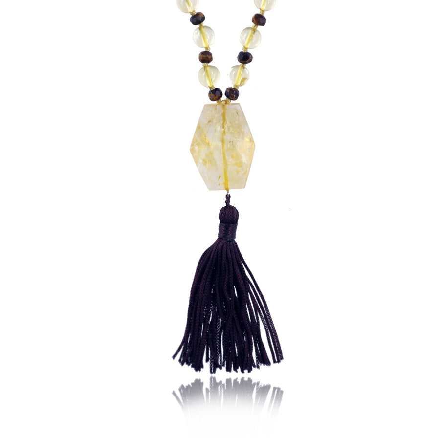 citrine pendant and back tassle of a mala necklace on white background