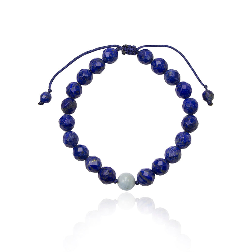 8 mm lapis lazuli beads and an aquamarine bead on string bracelet on white background