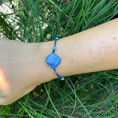 small aquamarine beads connected with artificial string bracelet and square kyanite centerpiece on wrist