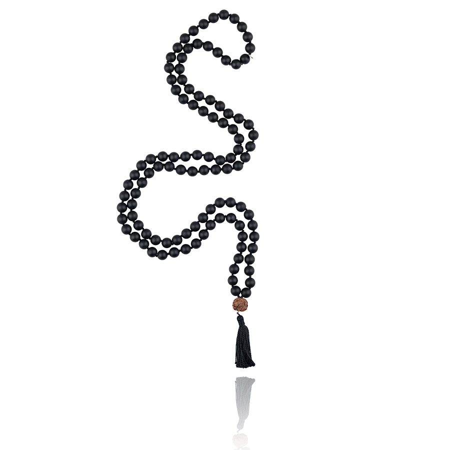 mala necklace with 108 beads of frosted onyx with rudraksa bead and black tassel on white background