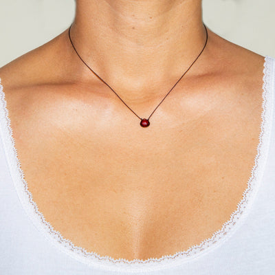garnet drop on black artificial string with silver 925 clasp short necklace on model in white top