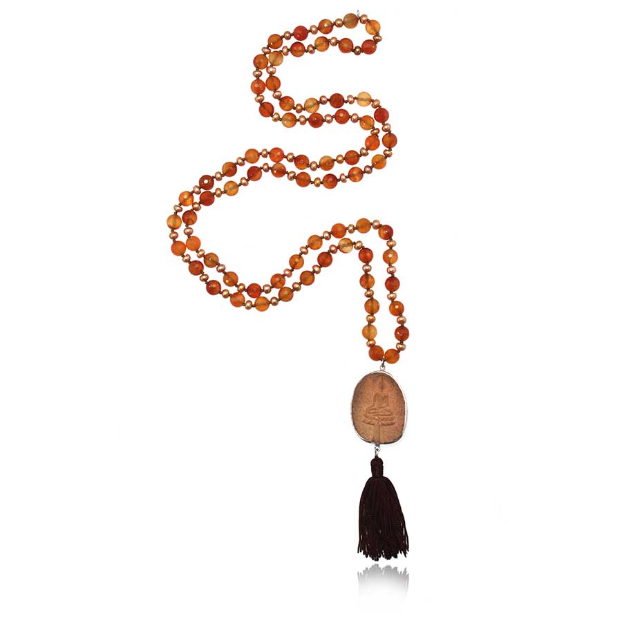 mala necklace with carnelian beads with baby pearls and buddha carved terracotta with tassel on white background