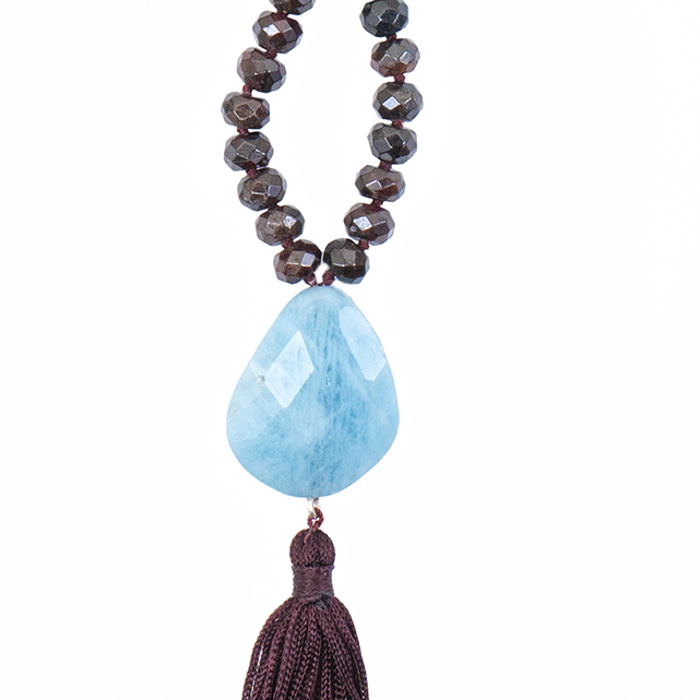 7x4mm Garnet Aquamarine Pendant with dark red tassel of a mala necklace on white background