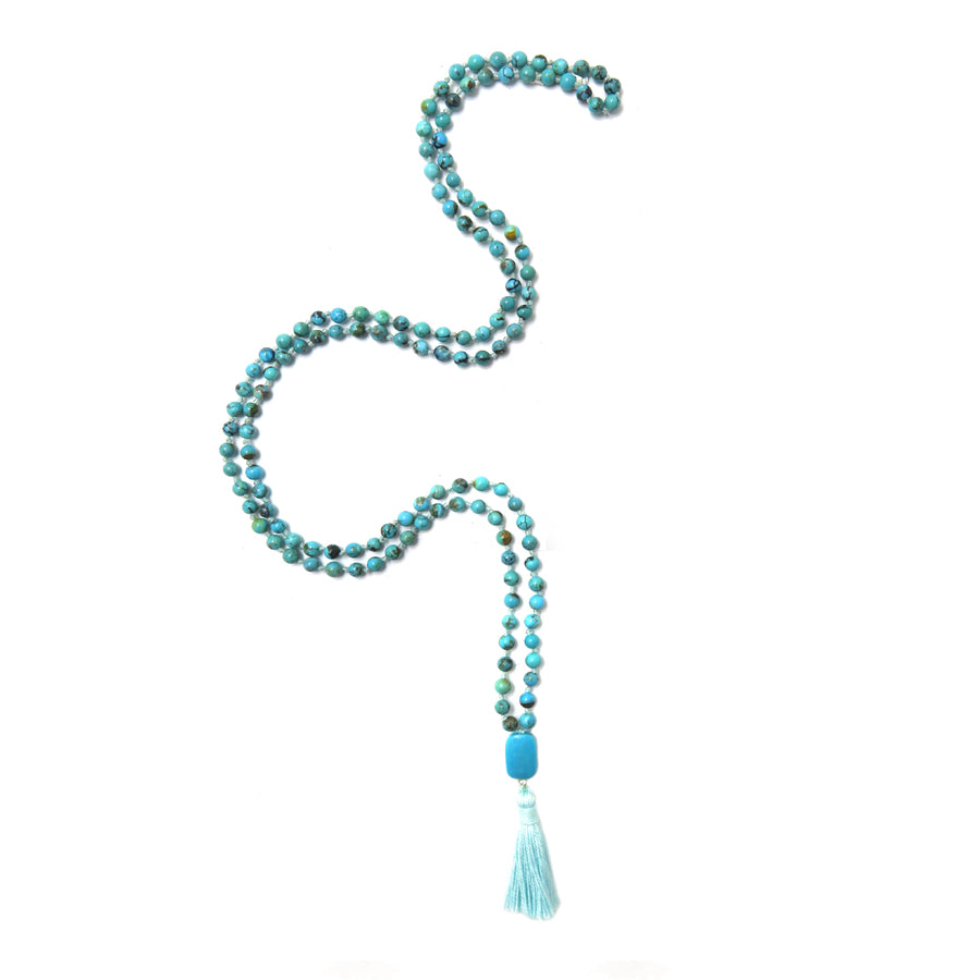 132 turquoise beads mala necklace with turquoise pendant and light blue tassel on white background